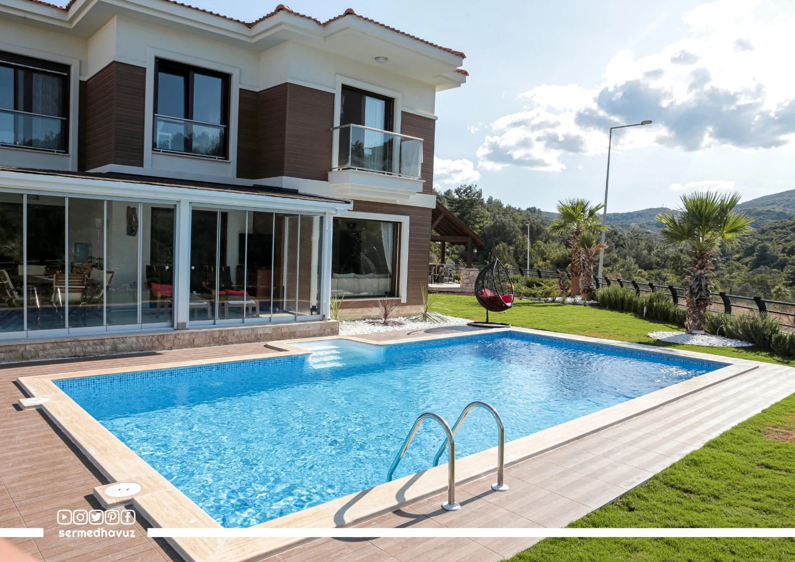 Villa, havuz, çevre kaplaması ve bahçenin birlikte görünümü