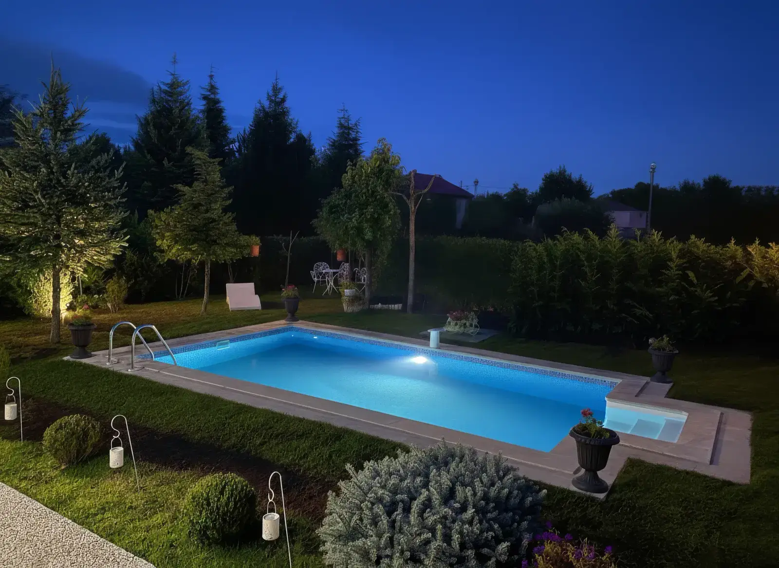 Villa bahçesinde alacakaranlıkta aydınlatılmış yüzme havuzu